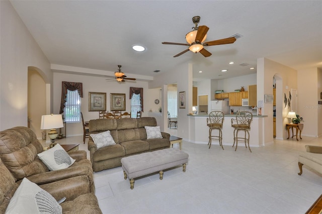2128 Worthington Greens Dr, Sun City Center, FL 33573 - living room featuring arched walkways, a ceiling fan, recessed lighting, light tile patterned floors, and baseboards