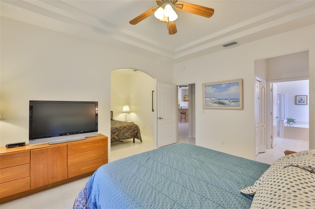 2128 Worthington Greens Dr, Sun City Center, FL 33573 - bedroom featuring arched walkways, light tile patterned flooring, a raised ceiling, ensuite bathroom, and ceiling fan