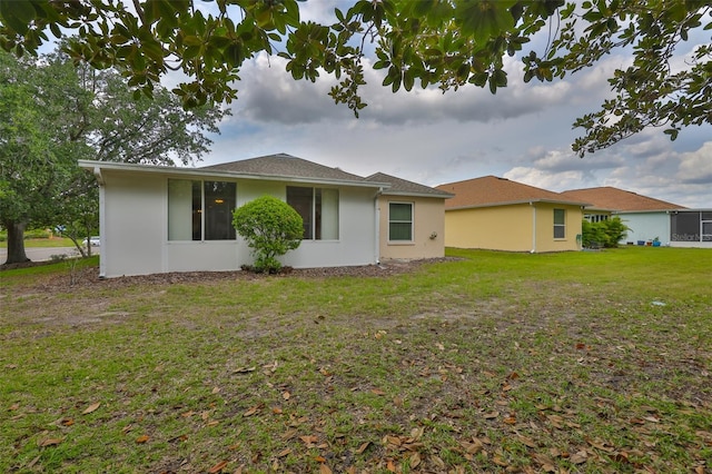 2128 Worthington Greens Dr, Sun City Center, FL 33573 - back of property featuring stucco siding and a lawn