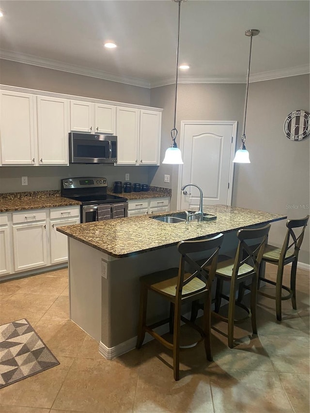 12619 Richezza Dr, Venice, FL 34293 - kitchen with stainless steel appliances, a sink, a center island with sink, crown molding, and white cabinetry
