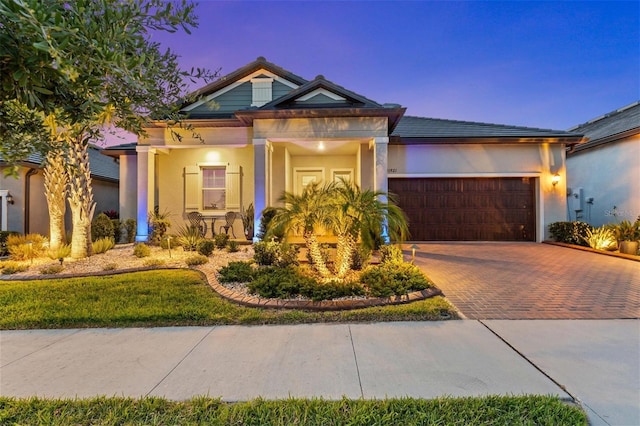 31921 Magna Gulf Loop, San Antonio, FL 33576 - view of front of property with decorative driveway, a garage, stucco siding, and a porch
