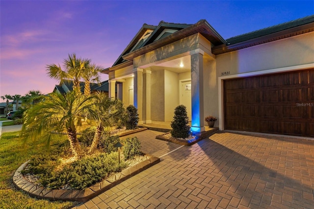 31921 Magna Gulf Loop, San Antonio, FL 33576 - view of front of home featuring stucco siding, an attached garage, and decorative driveway