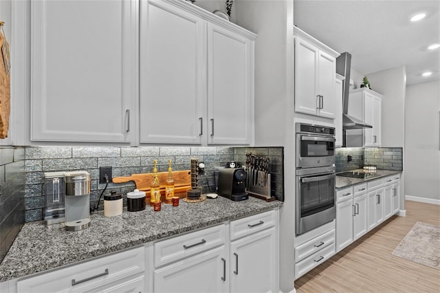 31921 Magna Gulf Loop, San Antonio, FL 33576 - kitchen with stainless steel double oven, white cabinetry, light stone counters, backsplash, and recessed lighting