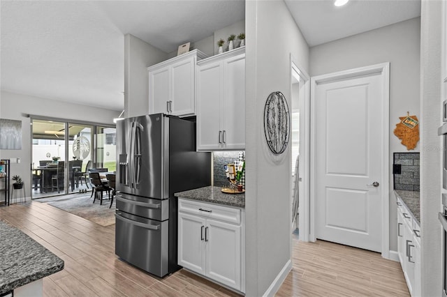 31921 Magna Gulf Loop, San Antonio, FL 33576 - kitchen featuring stainless steel refrigerator with ice dispenser, light wood-style floors, white cabinetry, dark stone counters, and recessed lighting