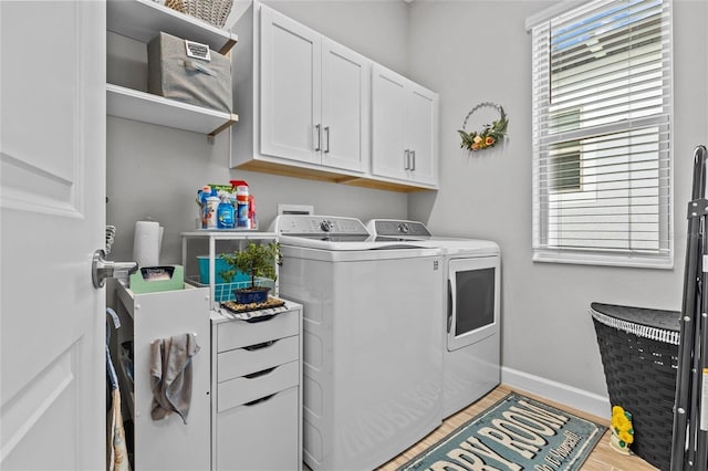 31921 Magna Gulf Loop, San Antonio, FL 33576 - laundry area featuring washer and clothes dryer, cabinet space, baseboards, and light wood-type flooring