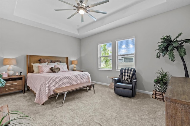 31921 Magna Gulf Loop, San Antonio, FL 33576 - bedroom featuring a tray ceiling, light carpet, baseboards, and a ceiling fan