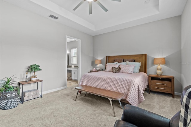31921 Magna Gulf Loop, San Antonio, FL 33576 - bedroom featuring carpet flooring, a tray ceiling, baseboards, and ensuite bath