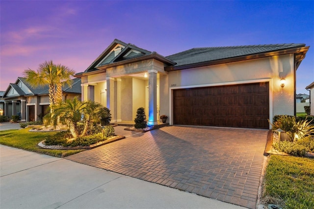 31921 Magna Gulf Loop, San Antonio, FL 33576 - view of front of home featuring stucco siding, a garage, and decorative driveway