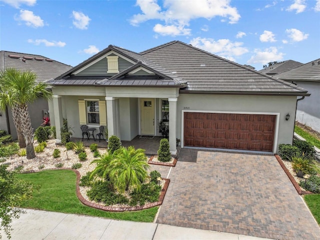 31921 Magna Gulf Loop, San Antonio, FL 33576 - view of front of home with stucco siding, an attached garage, a porch, and decorative driveway