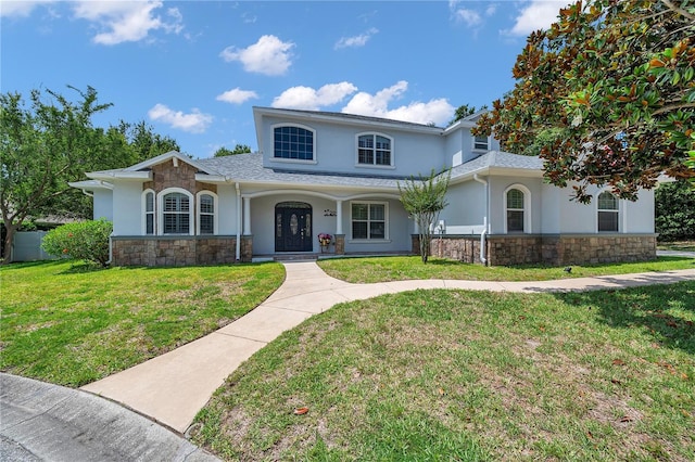 2011 Water Wheel Ct, Dunedin, FL 34698 - traditional-style house featuring stone siding, stucco siding, a front lawn, and covered porch
