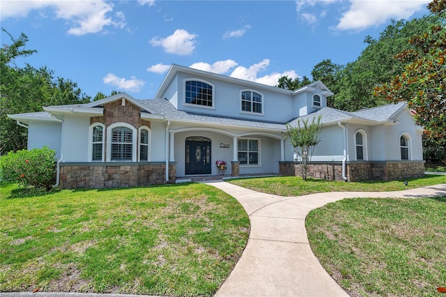 2011 Water Wheel Ct, Dunedin, FL 34698 - traditional home with stone siding, stucco siding, and a front yard
