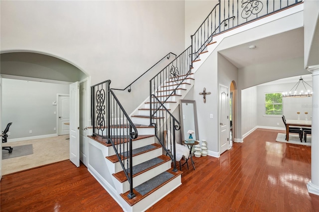 2011 Water Wheel Ct, Dunedin, FL 34698 - stairway with arched walkways, a towering ceiling, wood finished floors, baseboards, and a chandelier