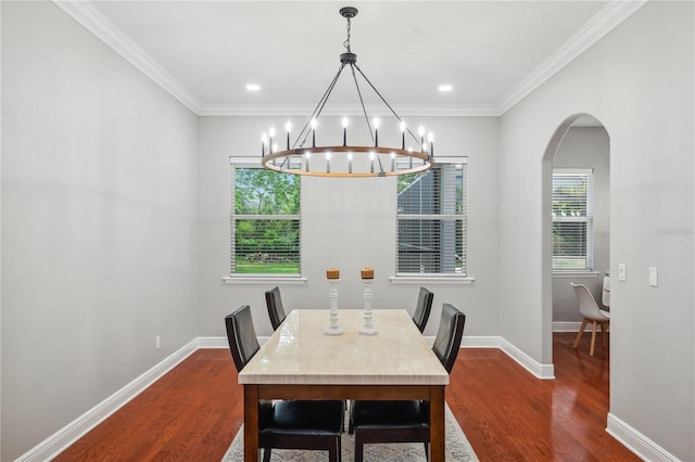 2011 Water Wheel Ct, Dunedin, FL 34698 - dining space featuring dark wood-style flooring, a chandelier, arched walkways, baseboards, and ornamental molding