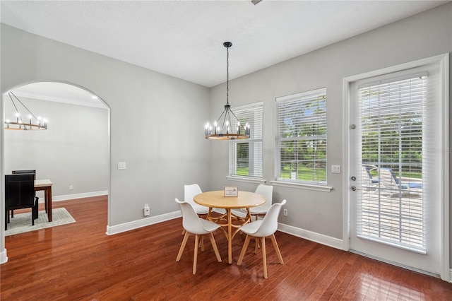 2011 Water Wheel Ct, Dunedin, FL 34698 - dining space featuring a chandelier, wood finished floors, baseboards, and arched walkways