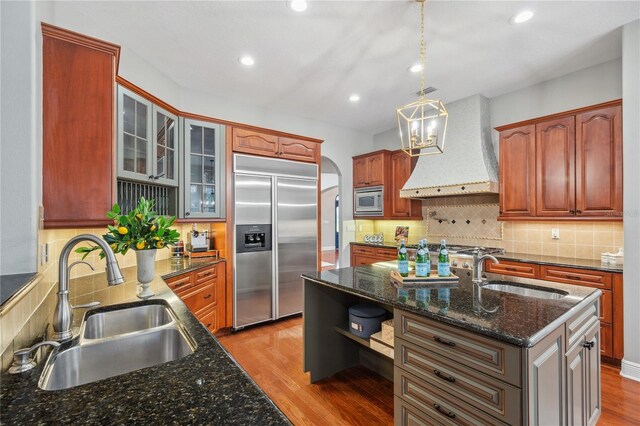 2011 Water Wheel Ct, Dunedin, FL 34698 - kitchen featuring built in appliances, a sink, wall chimney exhaust hood, light wood-type flooring, and recessed lighting
