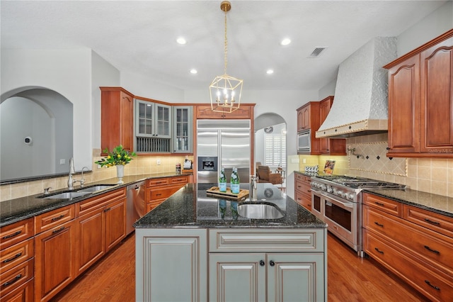 2011 Water Wheel Ct, Dunedin, FL 34698 - kitchen with built in appliances, a sink, wall chimney exhaust hood, arched walkways, and recessed lighting