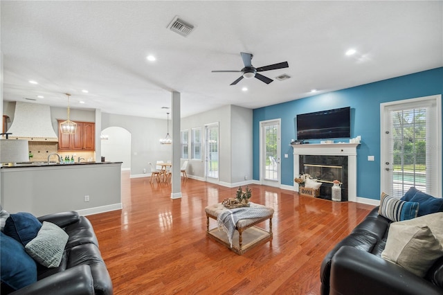 2011 Water Wheel Ct, Dunedin, FL 34698 - living room featuring recessed lighting, healthy amount of natural light, a ceiling fan, arched walkways, and a tiled fireplace