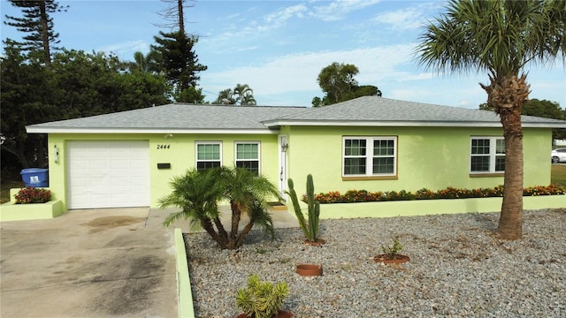2444 35th St N, Saint Petersburg, FL 33713 - ranch-style home featuring stucco siding, a garage, concrete driveway, and roof with shingles