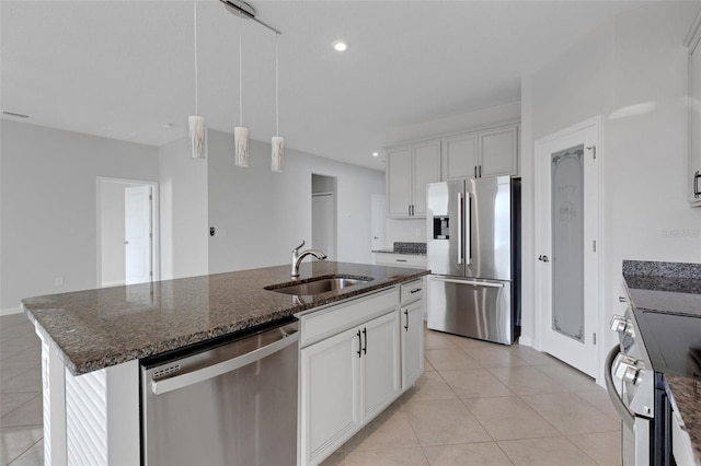 6211 114th Dr E, Parrish, FL 34219 - kitchen featuring stainless steel appliances, a sink, light tile patterned floors, an island with sink, and white cabinets