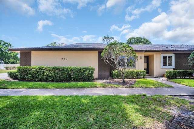 860 Maclaren Dr N Unit A, Palm Harbor, FL 34684 - ranch-style home with brick siding and a front yard
