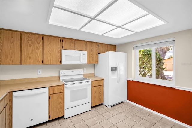 860 Maclaren Dr N Unit A, Palm Harbor, FL 34684 - kitchen featuring white appliances, light countertops, baseboards, light tile patterned floors, and brown cabinets