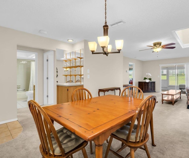 860 Maclaren Dr N Unit A, Palm Harbor, FL 34684 - dining space with light tile patterned floors, light carpet, ceiling fan, a chandelier, and a textured ceiling