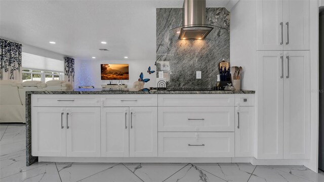 12416 Queensland Ln, Tampa, FL 33625 - kitchen featuring light marble finish flooring, wall chimney exhaust hood, dark stone counters, white cabinets, and recessed lighting