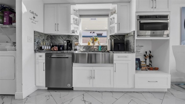12416 Queensland Ln, Tampa, FL 33625 - kitchen featuring stainless steel appliances, washer / dryer, light marble finish flooring, a sink, and white cabinets