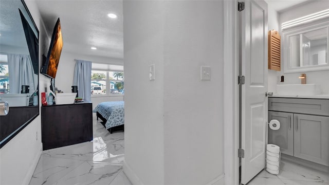 12416 Queensland Ln, Tampa, FL 33625 - ensuite bathroom with marble finish flooring, vanity, recessed lighting, and baseboards