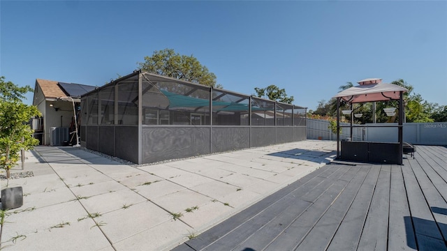 12416 Queensland Ln, Tampa, FL 33625 - wooden deck featuring a gazebo, central AC unit, and glass enclosure