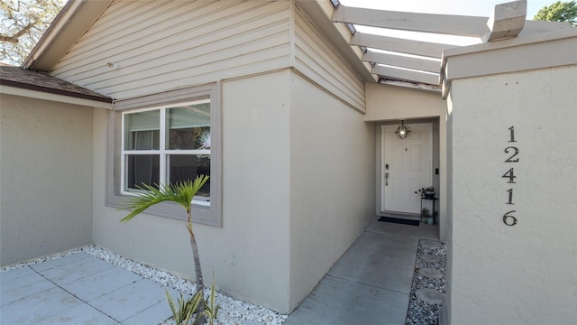 12416 Queensland Ln, Tampa, FL 33625 - entrance to property with stucco siding and a shingled roof