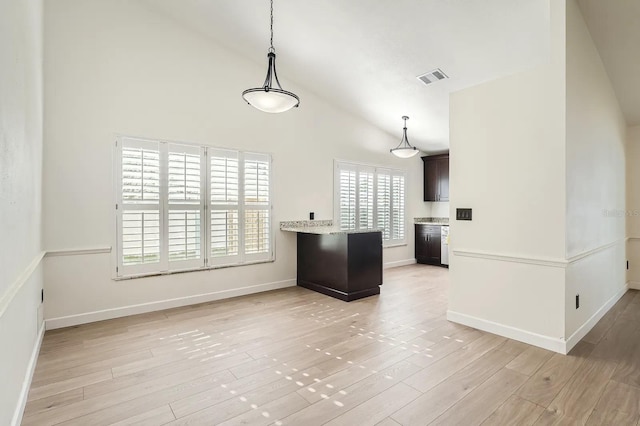 3058 Cara Ct, Palm Harbor, FL 34684 - kitchen with high vaulted ceiling, light countertops, plenty of natural light, and light wood-type flooring