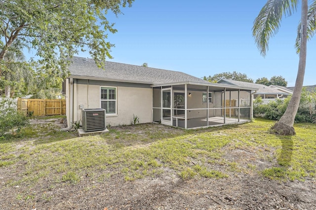 3058 Cara Ct, Palm Harbor, FL 34684 - back of property featuring central AC unit, a sunroom, stucco siding, and roof with shingles