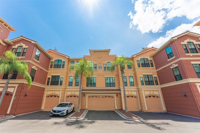 2741 Via Cipriani Unit 934B, Clearwater, FL 33764 - view of front of house with driveway, an attached garage, and stucco siding