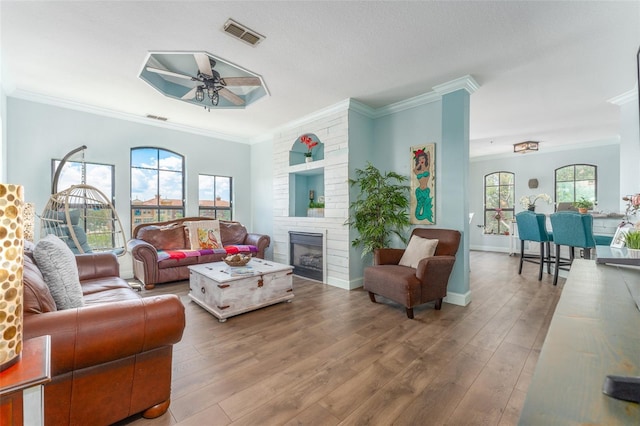 2741 Via Cipriani Unit 934B, Clearwater, FL 33764 - living area featuring ceiling fan, crown molding, wood finished floors, a fireplace, and baseboards