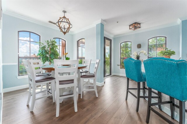 2741 Via Cipriani Unit 934B, Clearwater, FL 33764 - dining area with a chandelier, wood finished floors, ornamental molding, and baseboards