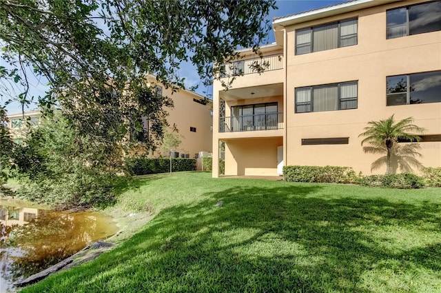 1531 Ember Ln, Tarpon Springs, FL 34689 - back of property with stucco siding, a yard, and a balcony