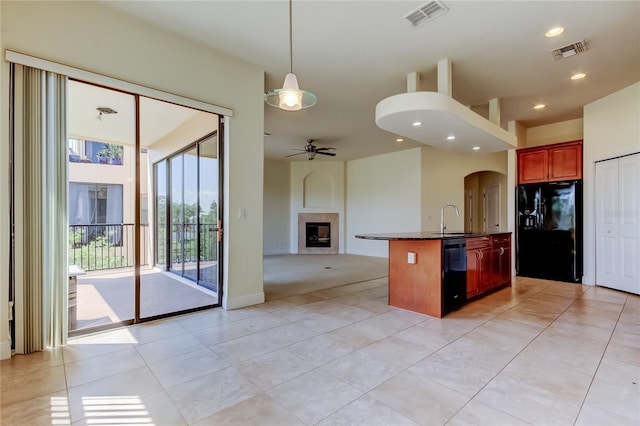 1531 Ember Ln, Tarpon Springs, FL 34689 - kitchen with black appliances, open floor plan, a tile fireplace, arched walkways, and ceiling fan