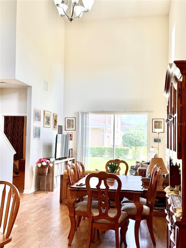 2130 Broadway View Ave, Brandon, FL 33510 - dining space with a towering ceiling, light wood-style floors, and a chandelier