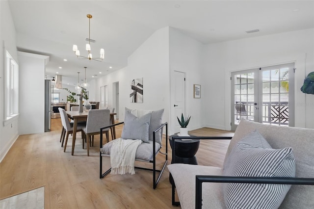 791 44th Ave N, Saint Petersburg, FL 33703 - living room featuring light wood-type flooring, a chandelier, french doors, and high vaulted ceiling