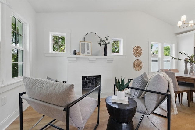 791 44th Ave N, Saint Petersburg, FL 33703 - living area with a fireplace, a chandelier, vaulted ceiling, and light wood-style floors