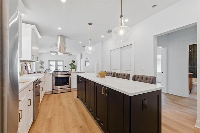 791 44th Ave N, Saint Petersburg, FL 33703 - kitchen with appliances with stainless steel finishes, island exhaust hood, light countertops, and recessed lighting