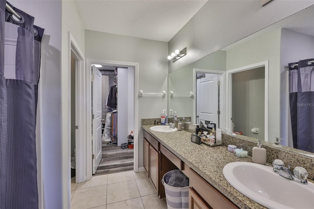 6512 Trent Creek Dr, Sun City Center, FL 33573 - bathroom with double vanity, tile patterned flooring, toilet, a textured ceiling, and a shower with curtain