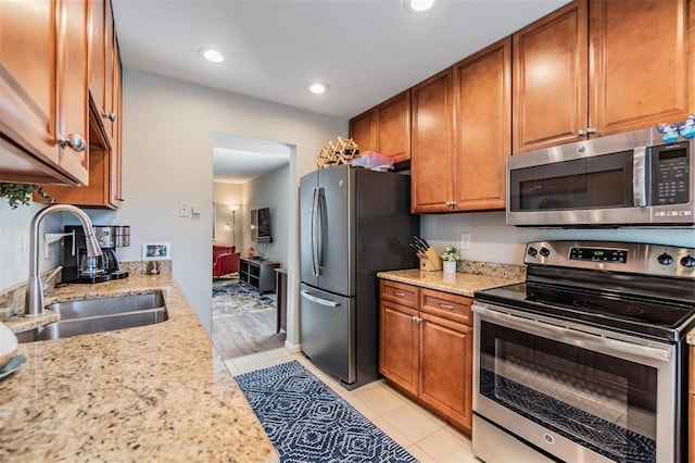 1515 Bayshore Blvd Unit 38, Dunedin, FL 34698 - kitchen with appliances with stainless steel finishes, brown cabinets, light stone countertops, and recessed lighting