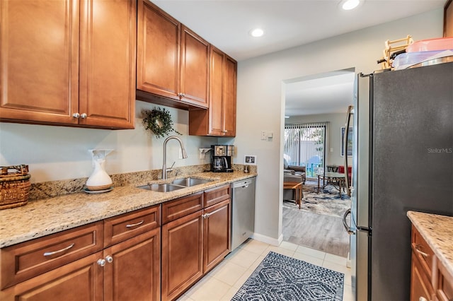 1515 Bayshore Blvd Unit 38, Dunedin, FL 34698 - kitchen featuring appliances with stainless steel finishes, brown cabinets, light stone countertops, light tile patterned flooring, and recessed lighting
