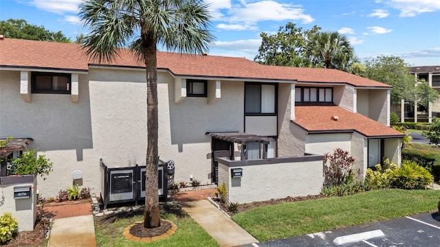 4160 Player Cir Unit 109, Orlando, FL 32808 - view of front of property with stucco siding, uncovered parking, and a shingled roof