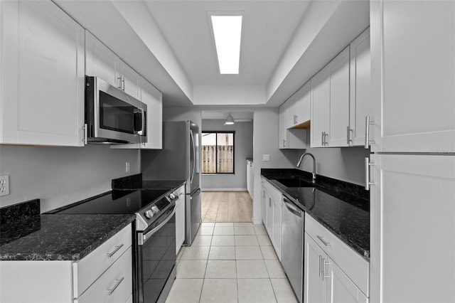 4160 Player Cir Unit 109, Orlando, FL 32808 - kitchen featuring stainless steel appliances, a sink, white cabinets, dark stone countertops, and light tile patterned flooring