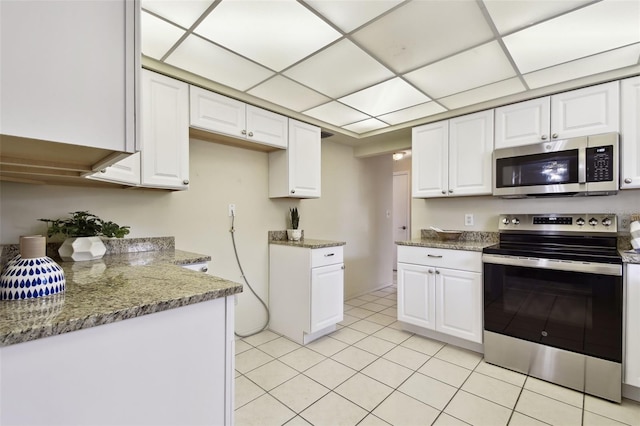 5825 Oakhurst Dr, Seminole, FL 33772 - kitchen featuring appliances with stainless steel finishes, white cabinetry, light tile patterned floors, and light stone counters