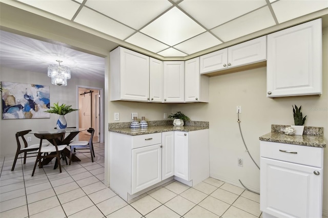 5825 Oakhurst Dr, Seminole, FL 33772 - kitchen with a chandelier, light tile patterned floors, white cabinets, and baseboards