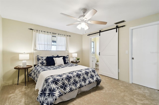 5825 Oakhurst Dr, Seminole, FL 33772 - carpeted bedroom with a barn door, ceiling fan, ensuite bathroom, and baseboards
